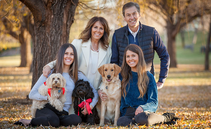 Family in park with three dogs