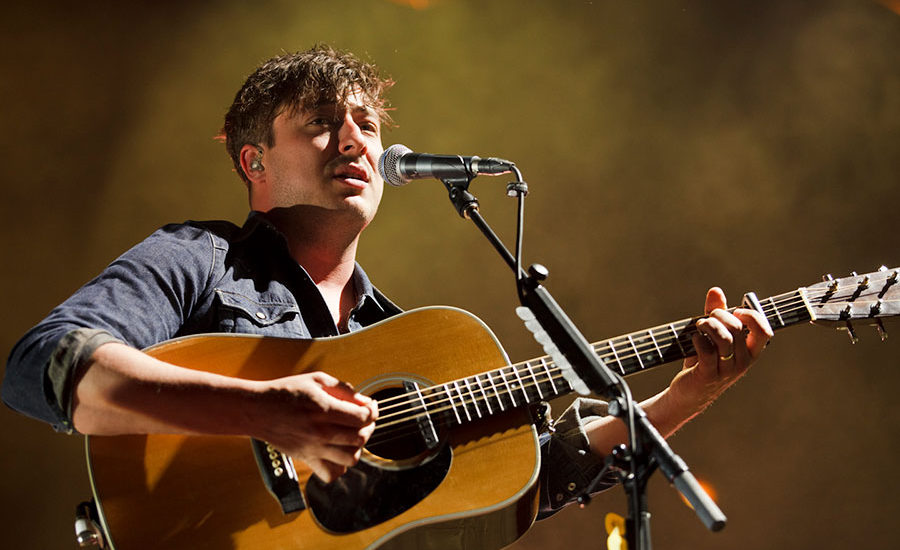 Marcus Mumford singing with guitar to crowd