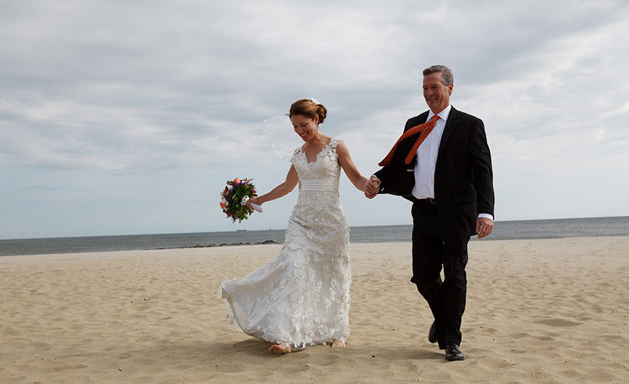 bride and groom walking on beach