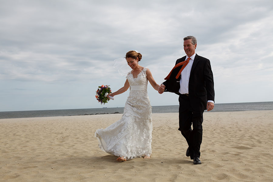 bride and groom walking on beach