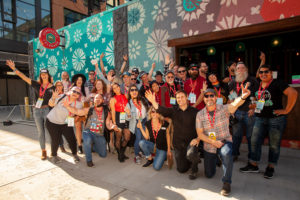group shot of people smiling in front of brewery